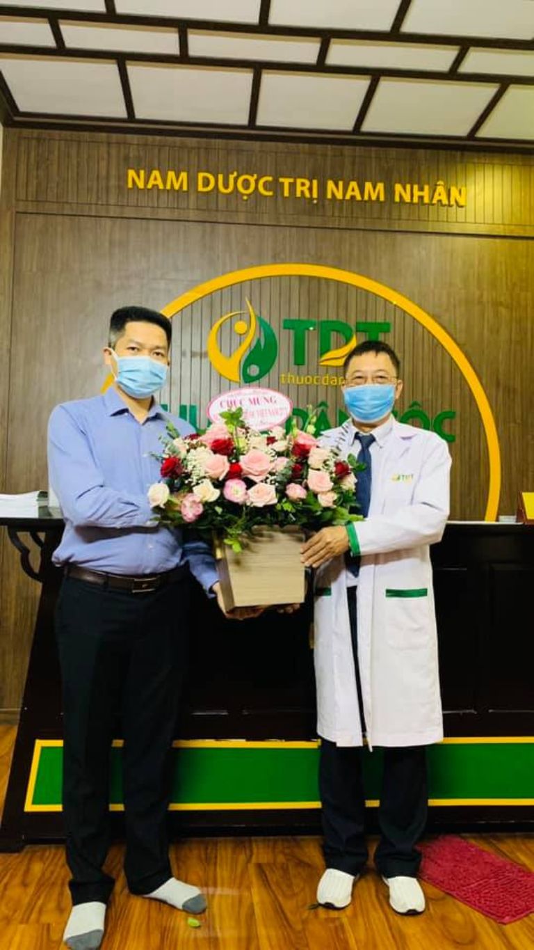 Ông Nguyễn Quang Hưng tặng hoa cho bác sĩ Lê Hữu Tuấn